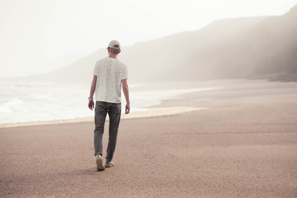 image of man walking alone on empty beach