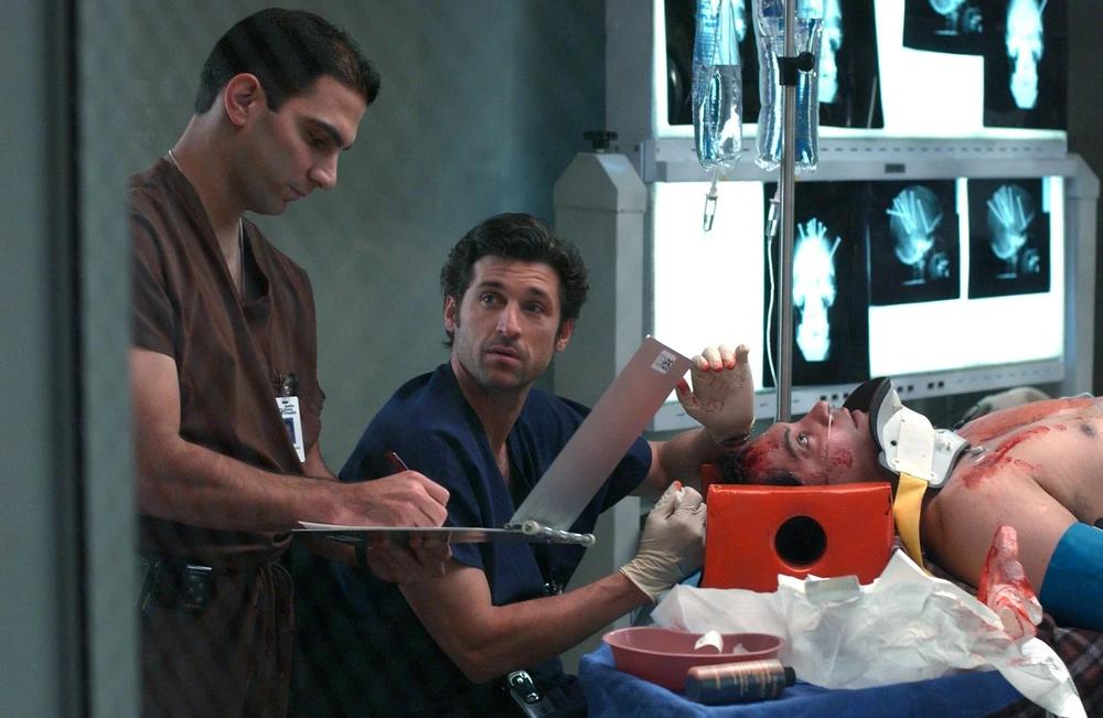image of Grey's Anatomy lead character, Derek, operating on patient with nails in his head
