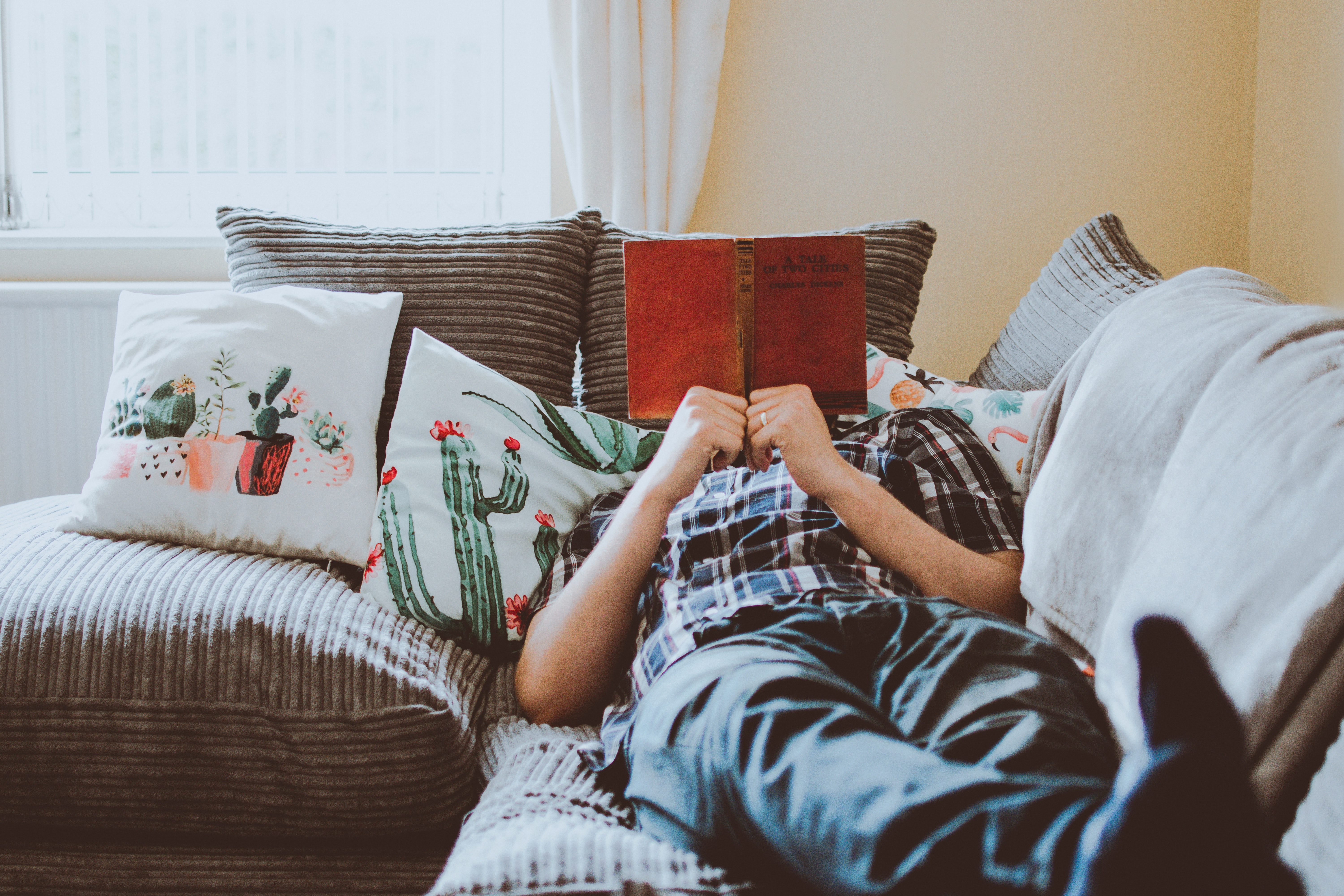 image of person relaxing on sofa and reading a book