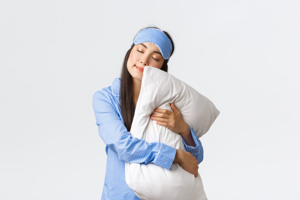 girl in pyjamas hugging a pillow